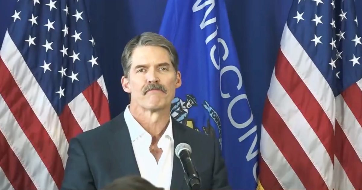 Eric Hovde in front of U.S. and Wisconsin flags