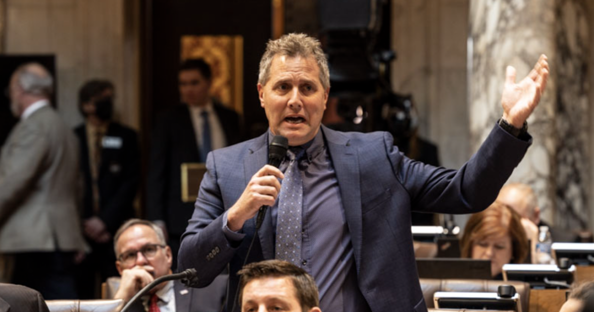 Rep. Shannon Zimmerman in chamber, raising hand speaking into microphone