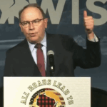 wisconsin republican tom tiffany at a podium with his thumb in the air