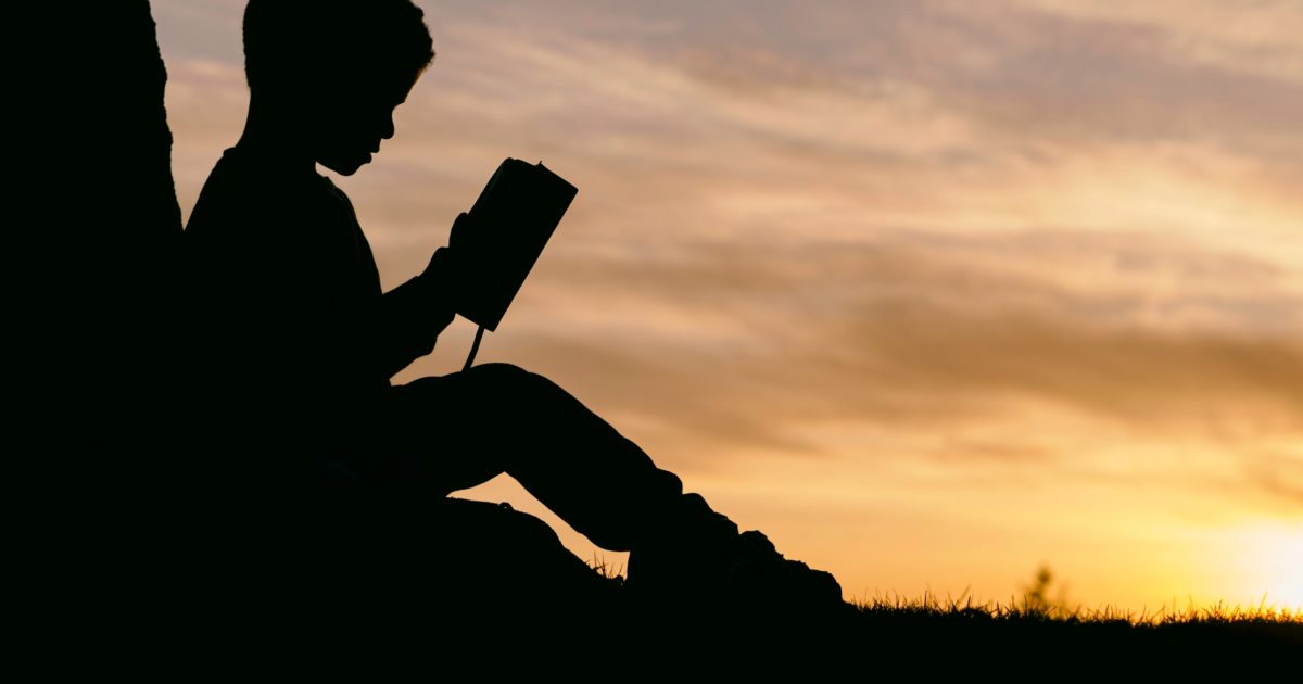 silhouette of child student reading school book