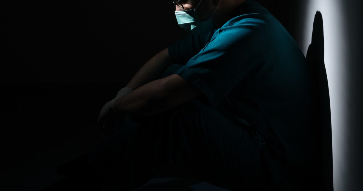 doctor sitting in the dark. mood is depressed.