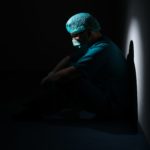 doctor sitting in the dark. mood is depressed.