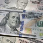 closeup on $100 bill with $50 bills