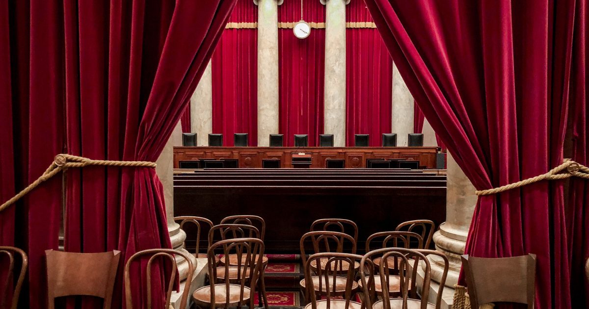 supreme court bench behind red curtains