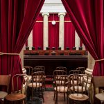 supreme court bench behind red curtains