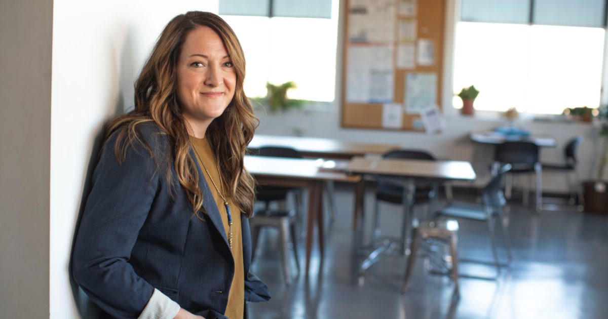teacher smiling standing in front of classroom