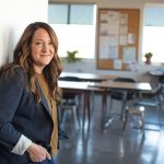 teacher smiling standing in front of classroom