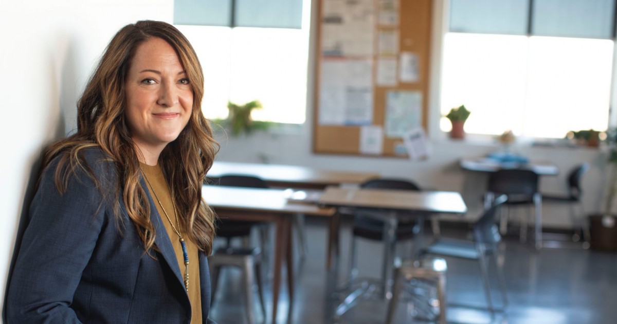 teacher smiling standing in front of classroom