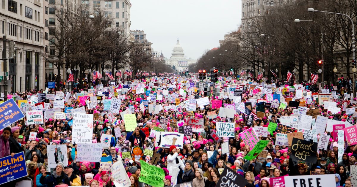 crowd holding signs in womens march